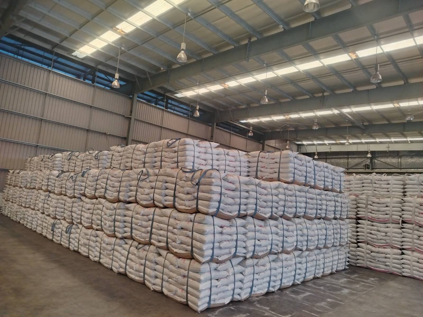 Workers stacking 50kg bags inside the Thilawa warehouse